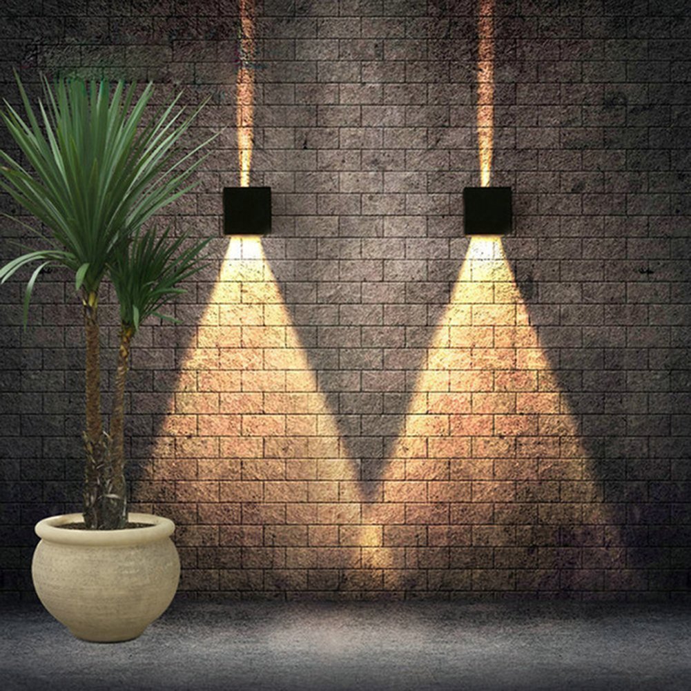 Applique murale interieur/exterieur 12w noire avec angle de faisceau reglable eclaire un mur en brique avec lumière chaude