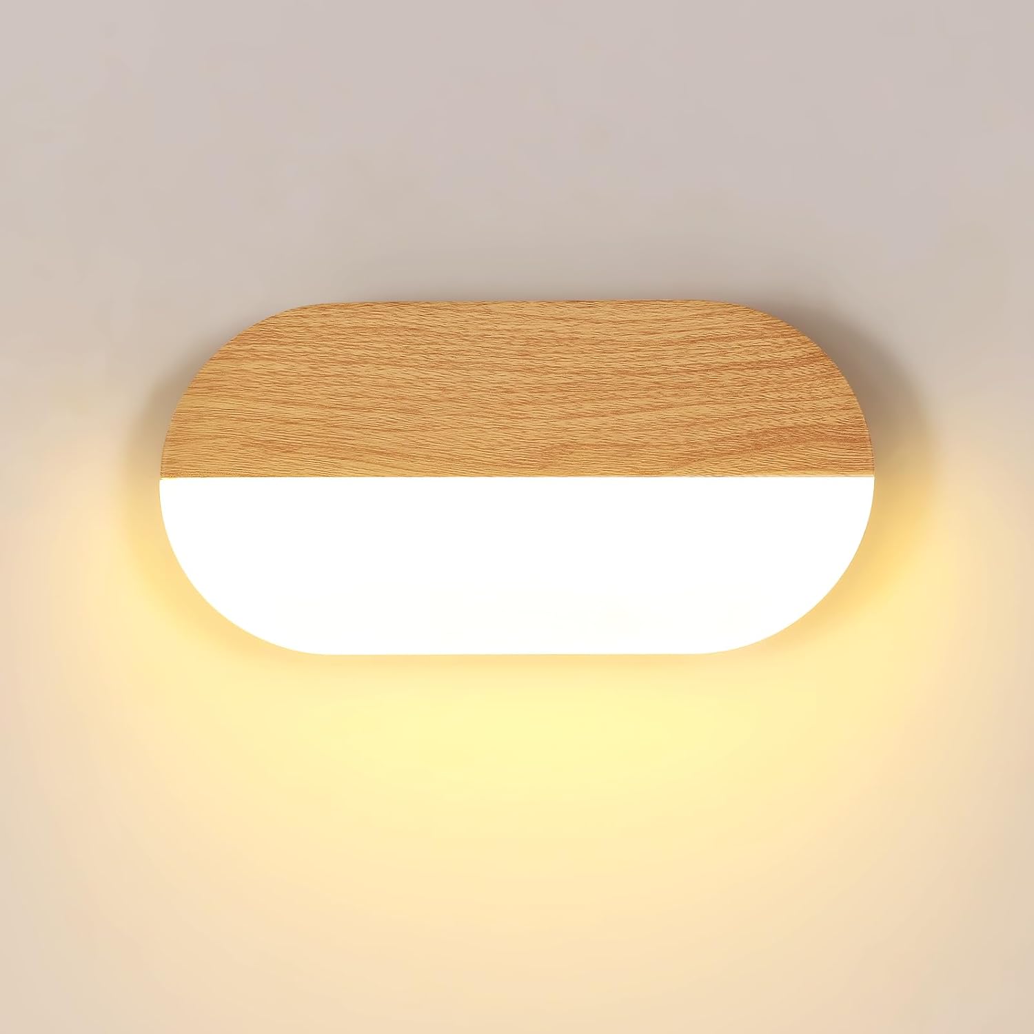 Vue frontale applique murale LED ovale bois clair grain fin sur fond crème, contraste acrylique translucide