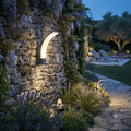 Applique murale LED noire forme ondulée élégante montée sur mur pierre ancienne avec vigne et fleurs violettes