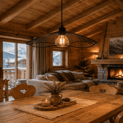 Suspension en métal noir et or dans une pièce à ambiance chalet avec murs en bois, éclairage chaud et décor chaleureux